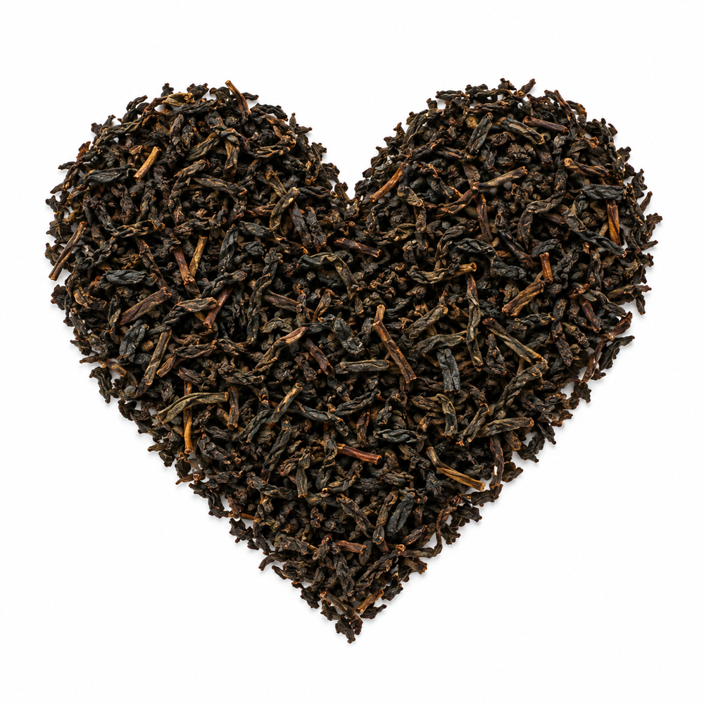 Earl grey cream – svart te arrangerat som ett hjärta på vit bakgrund
