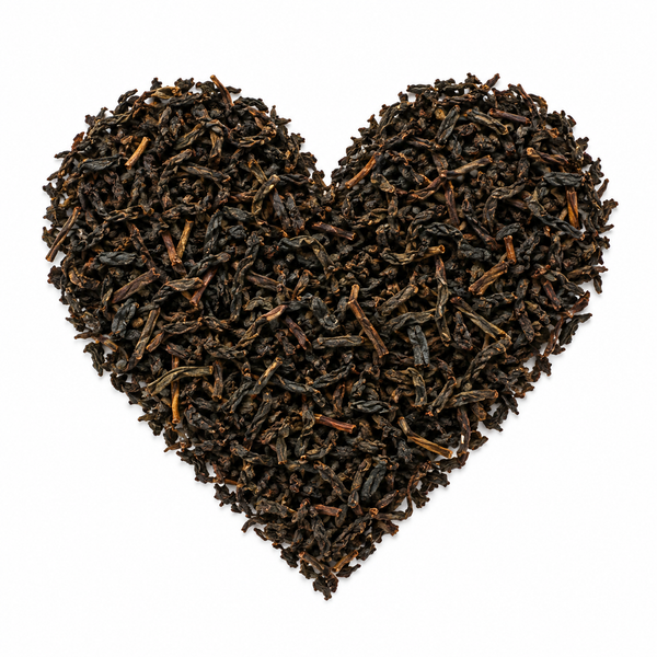 Earl grey cream – svart te arrangerat som ett hjärta på vit bakgrund